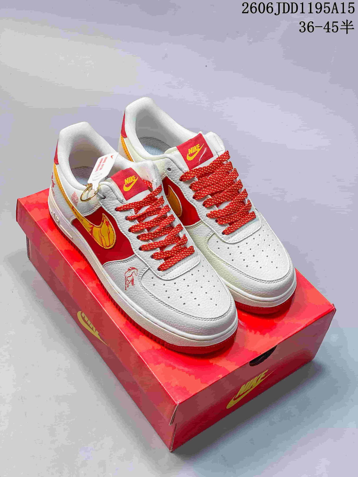 Pair of white, red, and yellow Nike Air Force 1 Low sneakers with horse-themed details on a red box