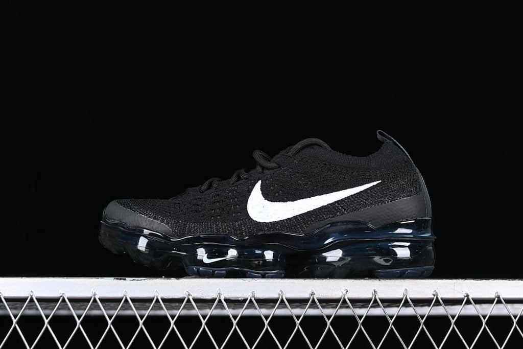 Side view of a black Nike Air VaporMax sneaker with a white Swoosh and visible air-cushioned sole.