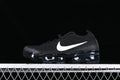Side view of a black Nike Air VaporMax sneaker with a white Swoosh and visible air-cushioned sole.