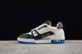 Side view of a white, black, and blue LV Trainer sneaker