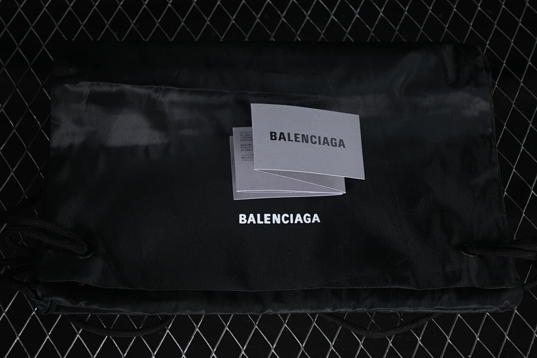 Black branded fabric bag and printed cards shown with the sneakers