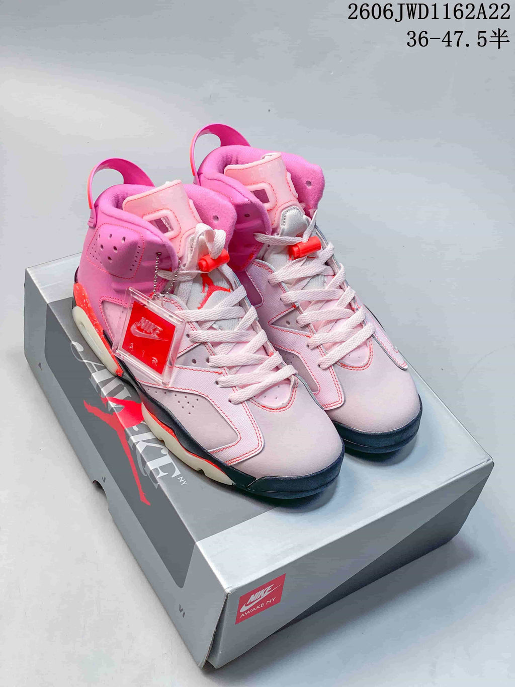 Pair of pink Jordan x Awake NY Air Jordan 6 sneakers displayed on a shoebox