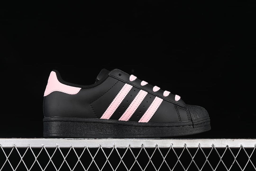 Side profile showing the black upper, pink stripes, and shell toe