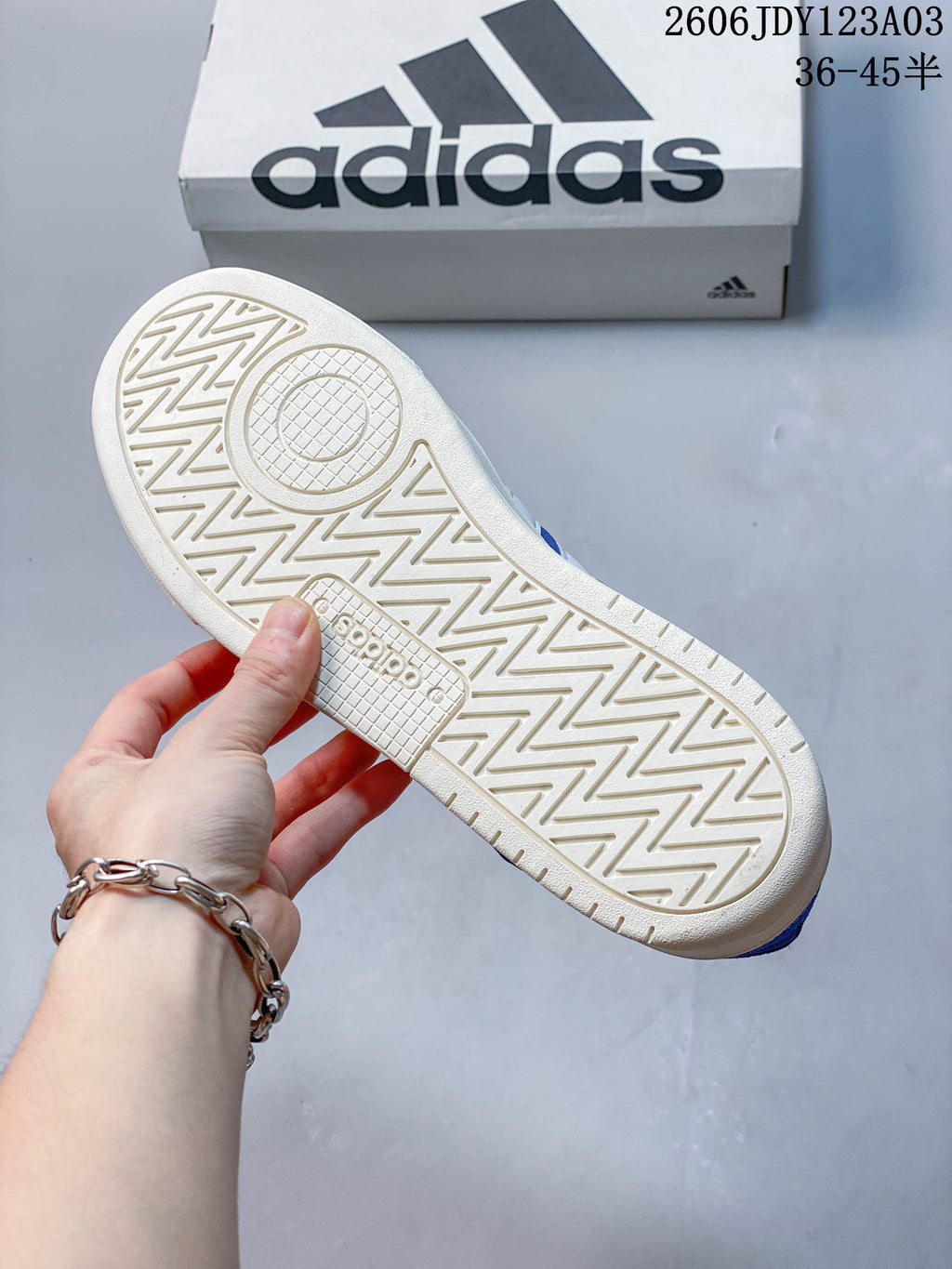 Close-up of the off-white outsole and patterned tread on the blue sneakers