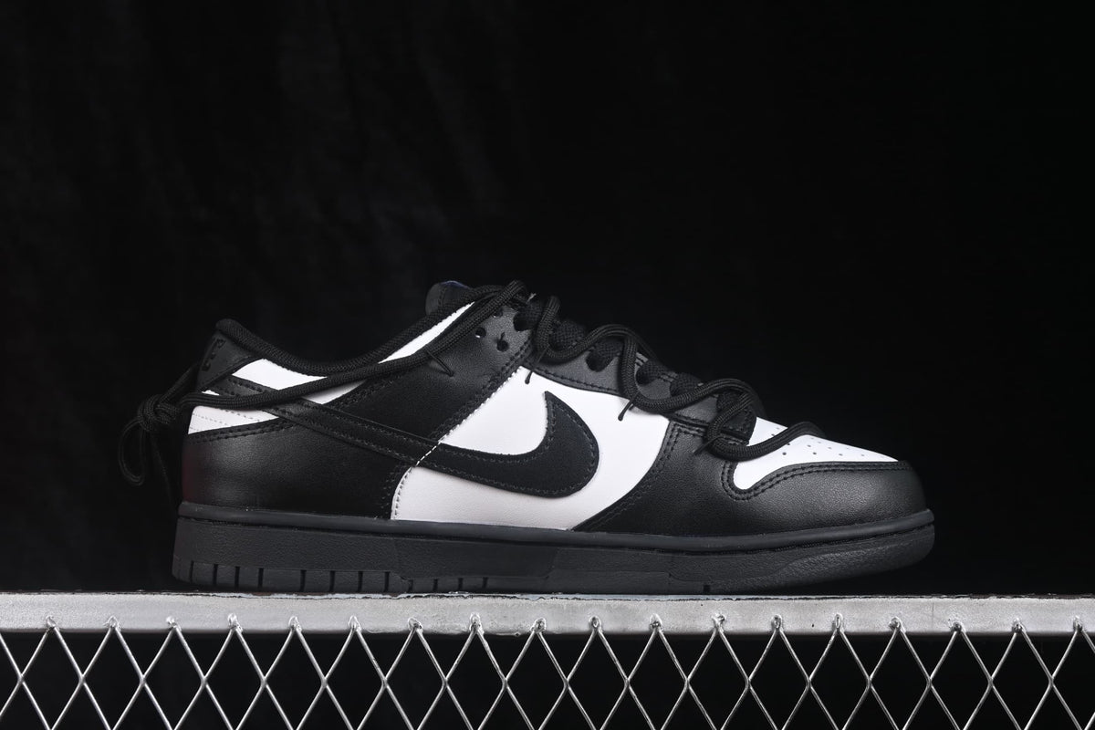 Side profile of a black and white sneaker showing the perforated white toe box, black overlays, and black outsole.