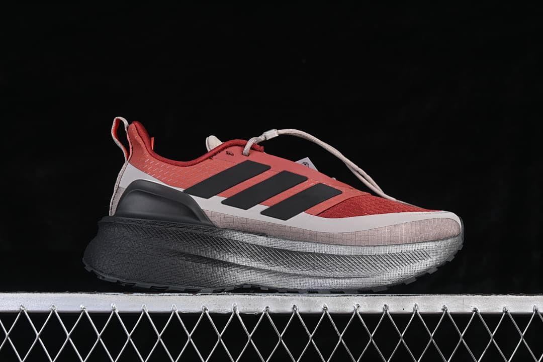 Side profile of the red, gray and black running shoe
