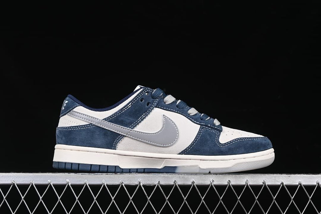Side profile of a navy, white, and gray low-top sneaker