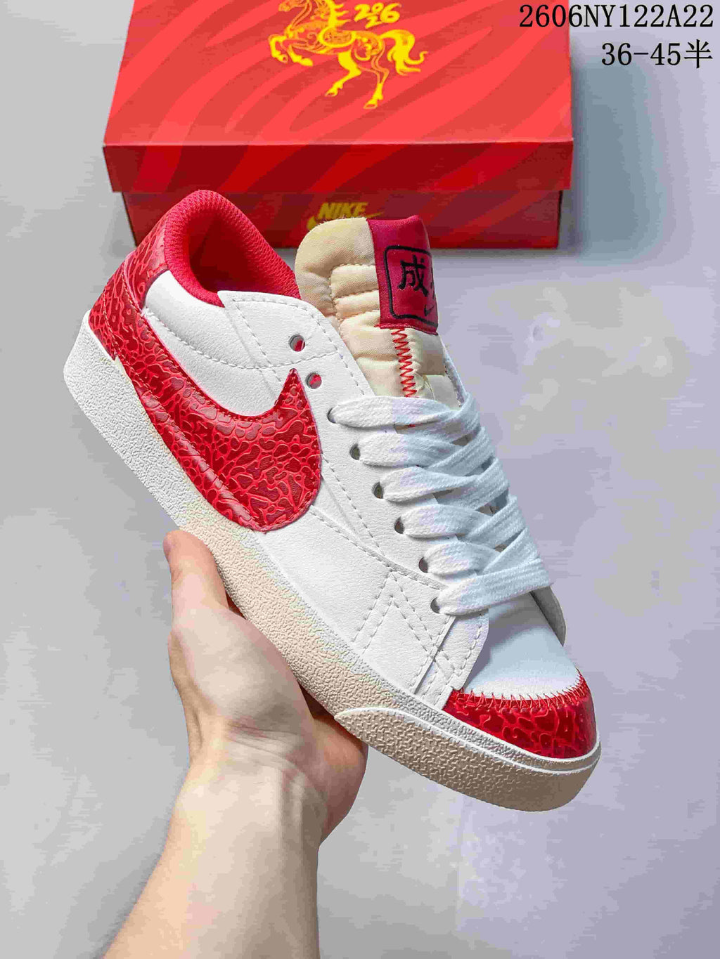 Close-up of a white sneaker with red patterned Swoosh and toe accents