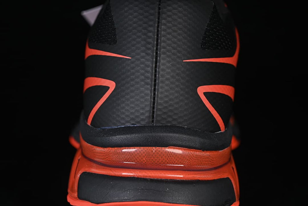 Rear view highlighting the black heel and tomato-red midsole