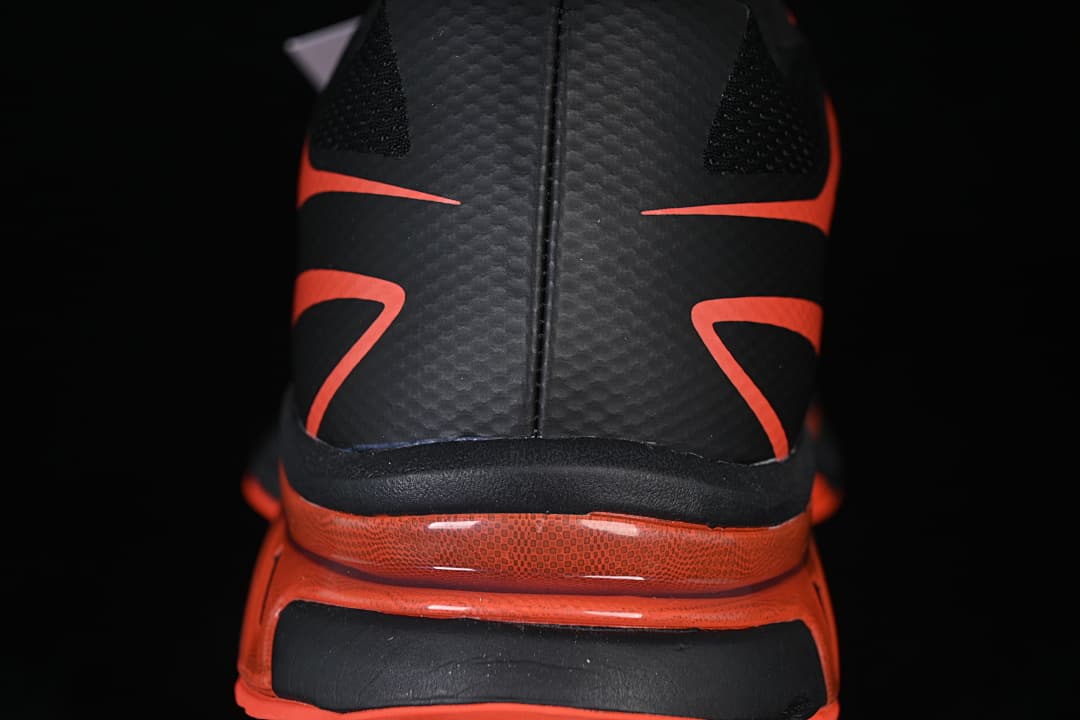 Rear view highlighting the black heel and tomato-red midsole