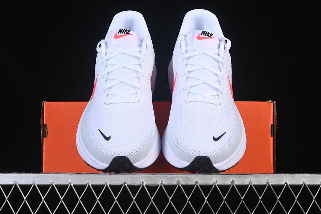Front view of the pair of white running shoes displayed on the box