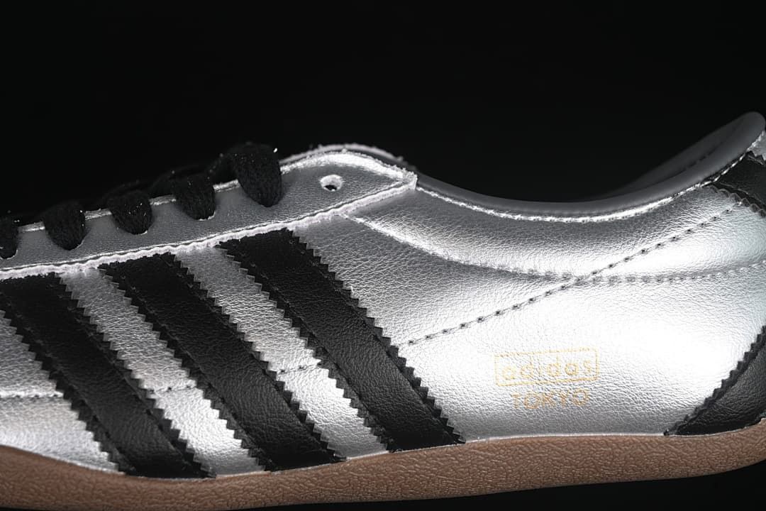 Close-up of the silver side panel, black stripes, and gum-colored outsole