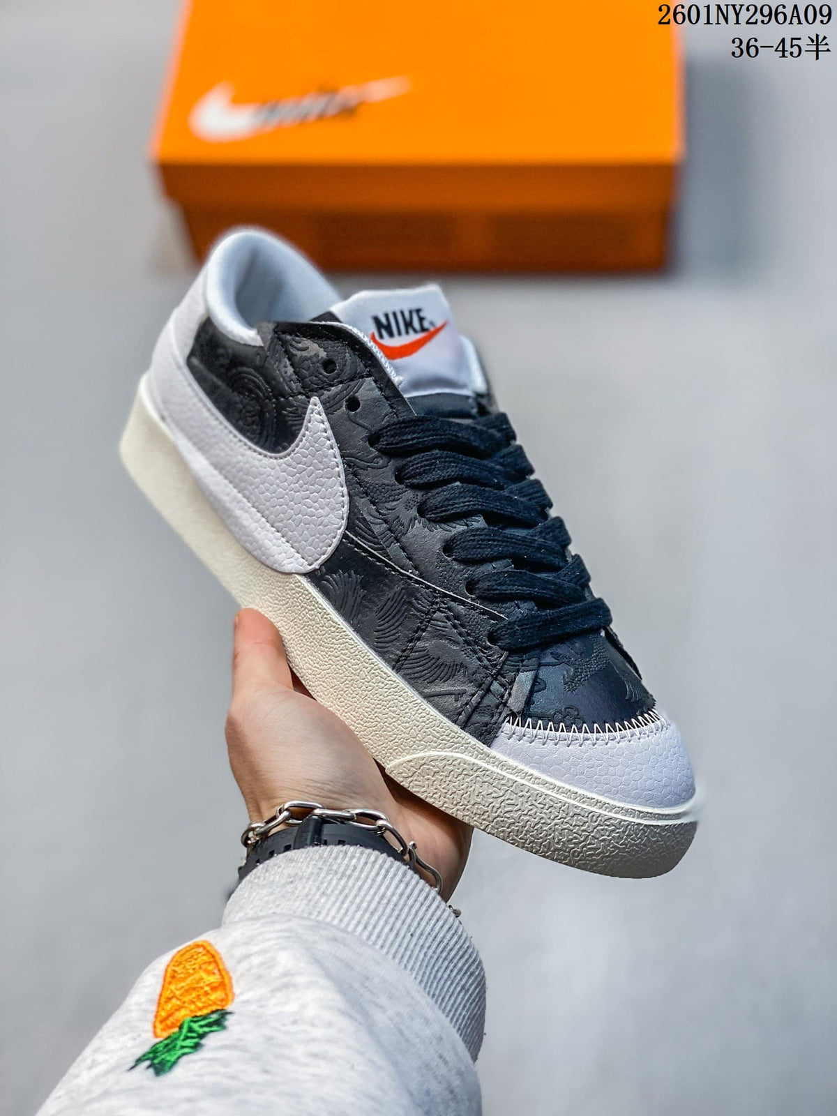 Black and white Nike Blazer Low '77 Jumbo sneaker with patterned black panels and a white Swoosh.