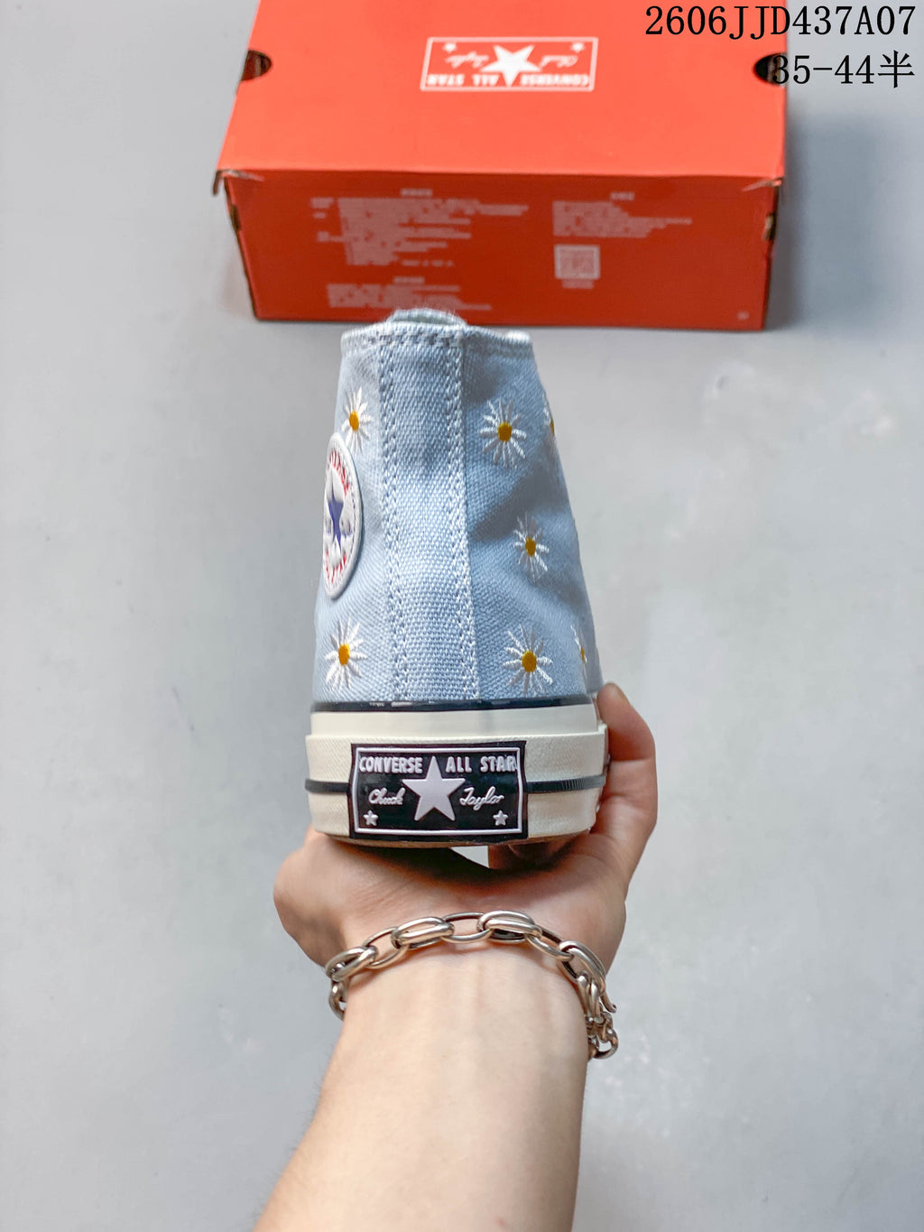 Rear view of the high-top sneaker with daisy embroidery and a heel label