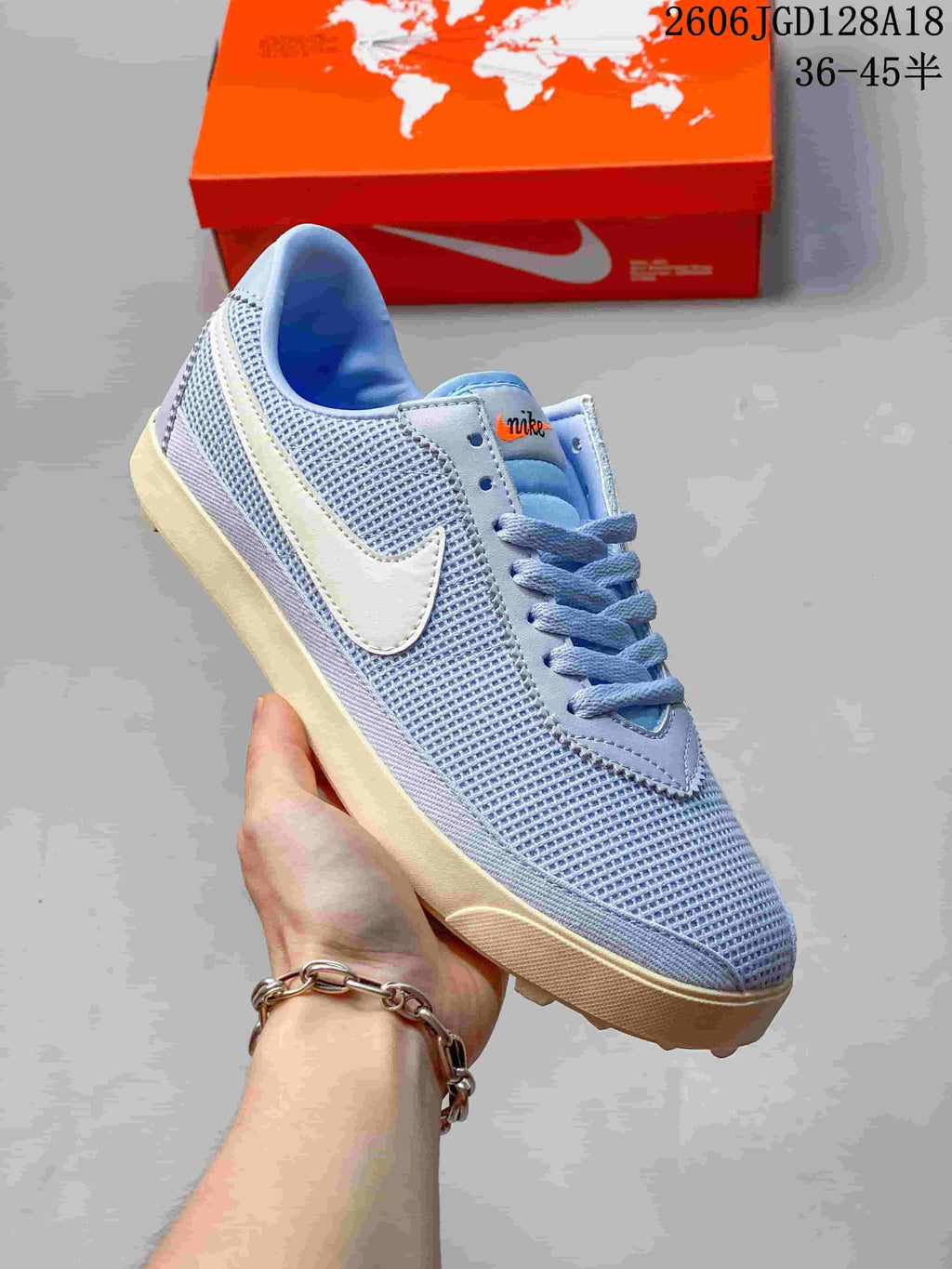 Close view of a pale blue Nike Astrograbber sneaker with mesh-style panels, a light-colored side Swoosh, and lace-up fastening.