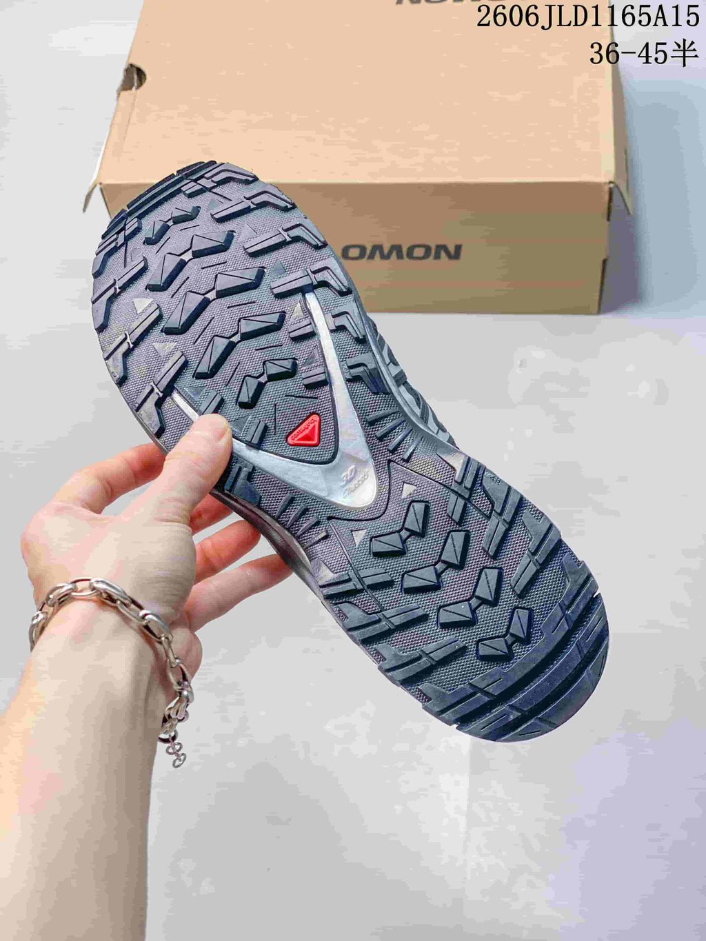 Close-up of the lugged outsole on a charcoal gray trail shoe; image overlay lists sizes 36–45.5.