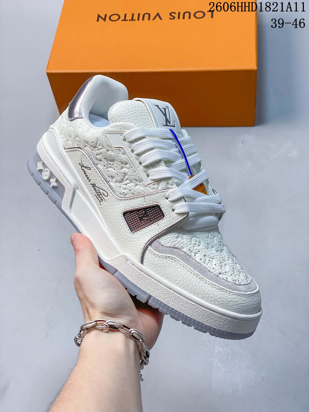 Angled side view of the white Trainer sneaker with textured panels and sculpted outsole.