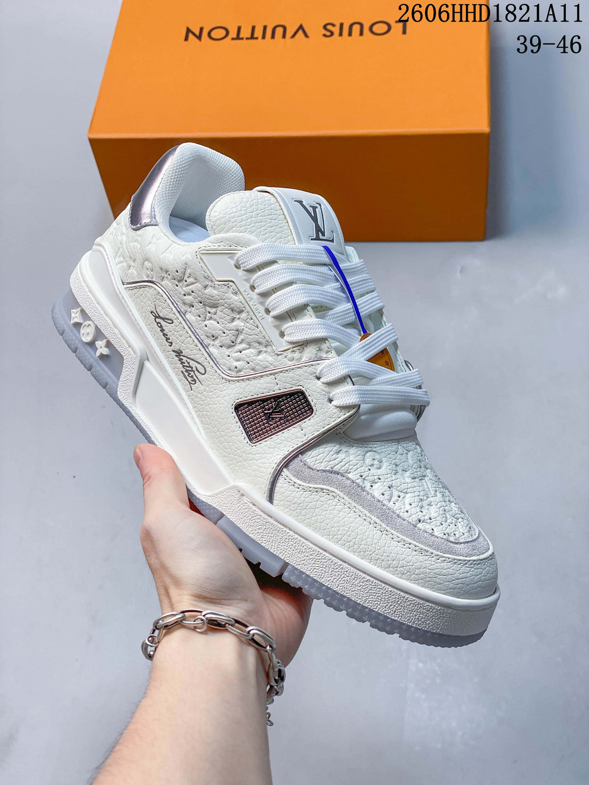 Angled side view of the white Trainer sneaker with textured panels and sculpted outsole.