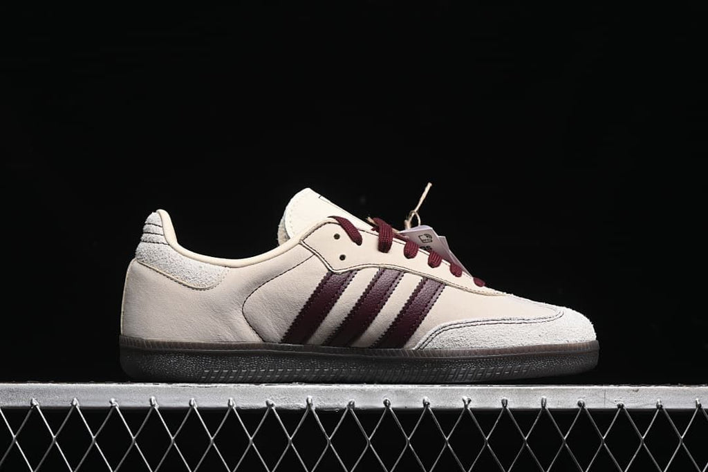 Side profile showing the cream upper, burgundy stripes, and dark sole.
