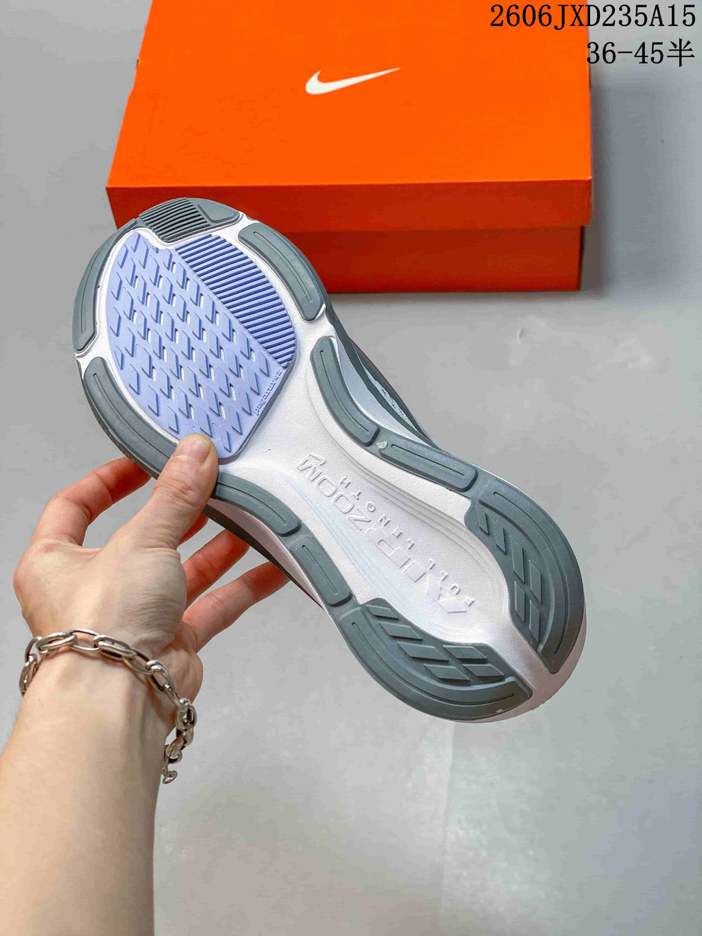 Outsole view of the Nike Pegasus 42 shoe, showing grey and lavender tread sections