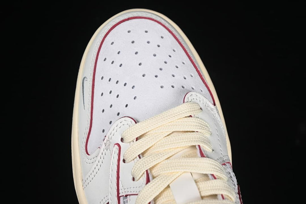 Top view of perforated toe box with red outlining and cream laces.