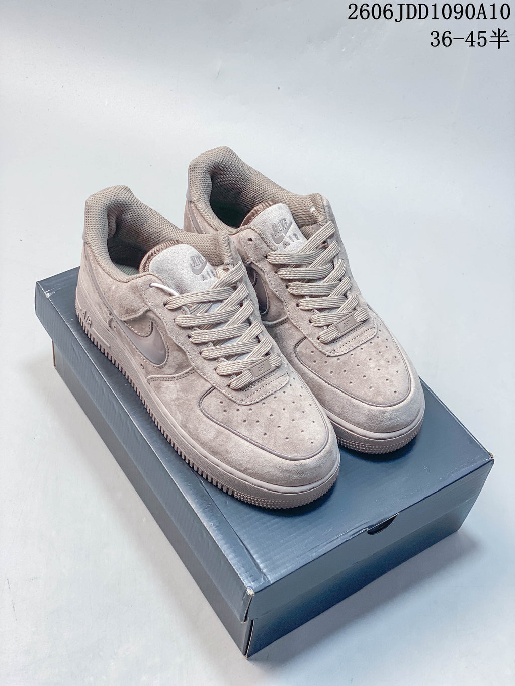 Pair of light gray Nike Air Force 1 low-top sneakers displayed on a shoe box.