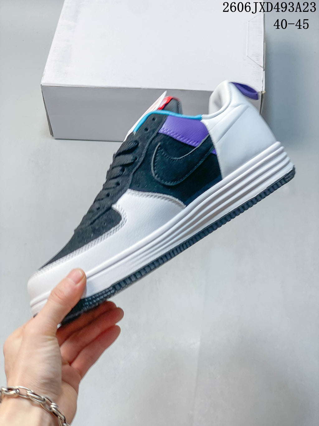 Side view of the sneaker with white and navy panels and a raised midsole