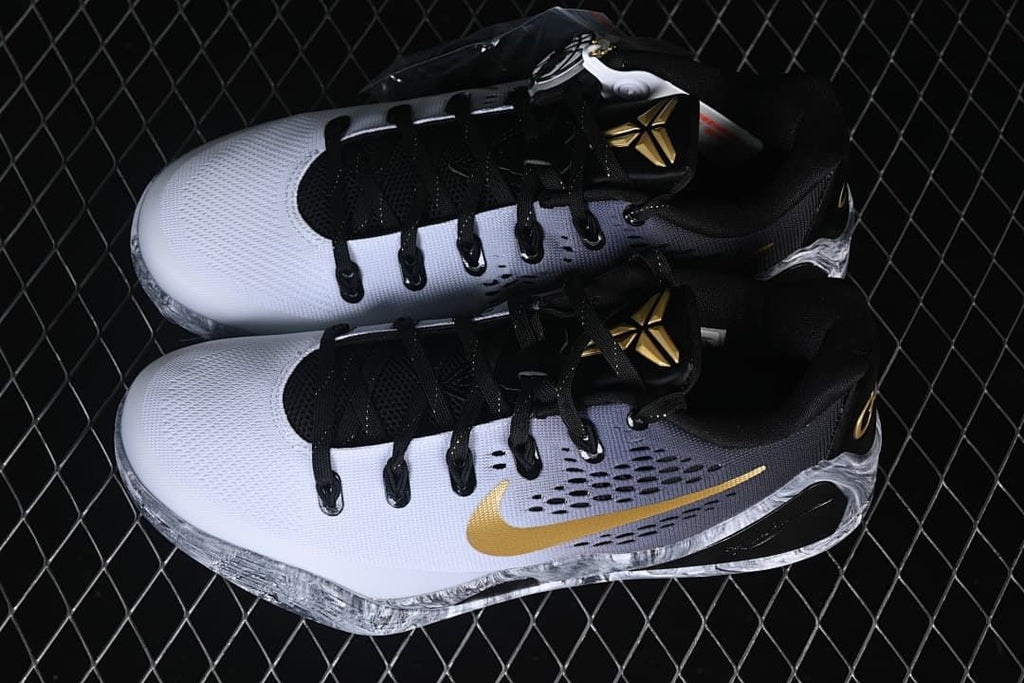 Pair of white, gray, black, and gold low-top basketball shoes