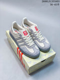 Pair of white and grey Adidas Originals Gazelle Indoor sneakers beside horse-patterned packaging