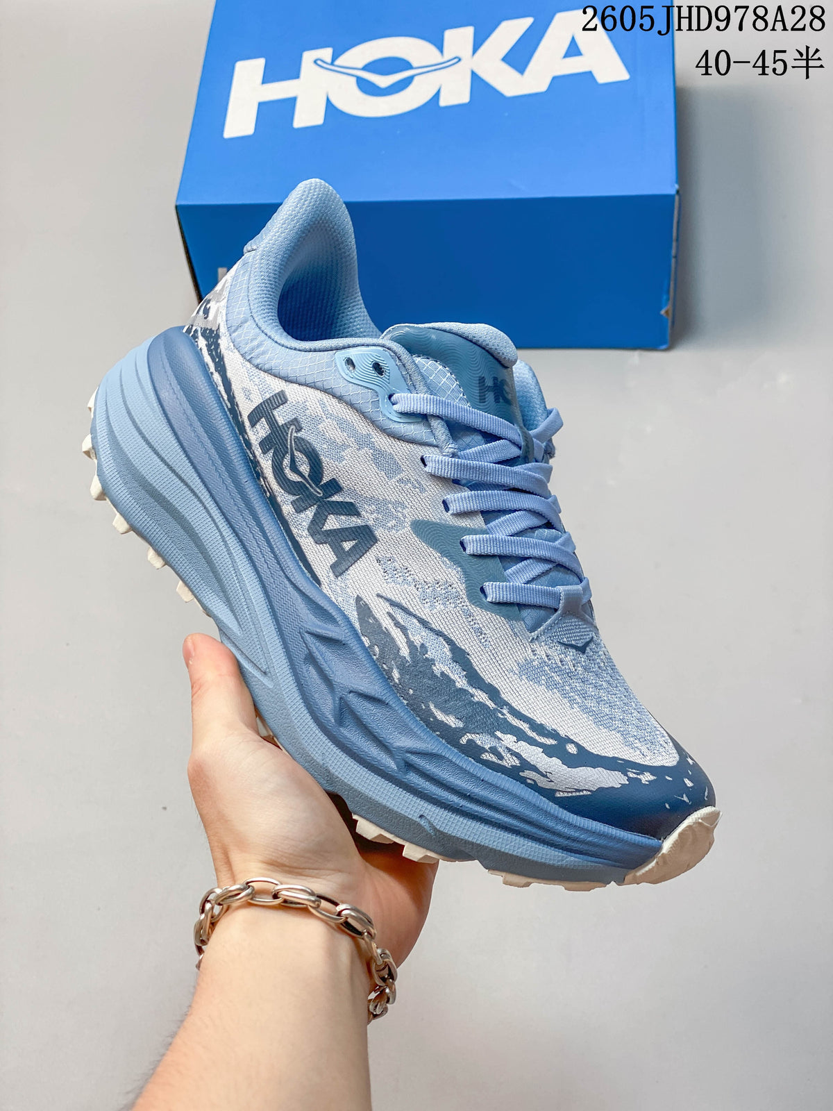 Angled side view of the blue and white HOKA Stinson 7 trail shoe