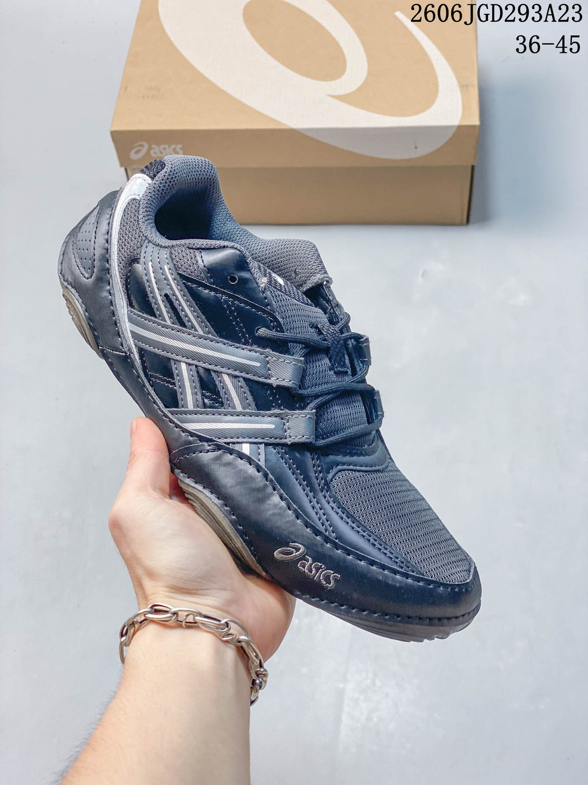 Dark navy and gray ASICS Gel-Pickax sneaker with mesh panels and layered side details.