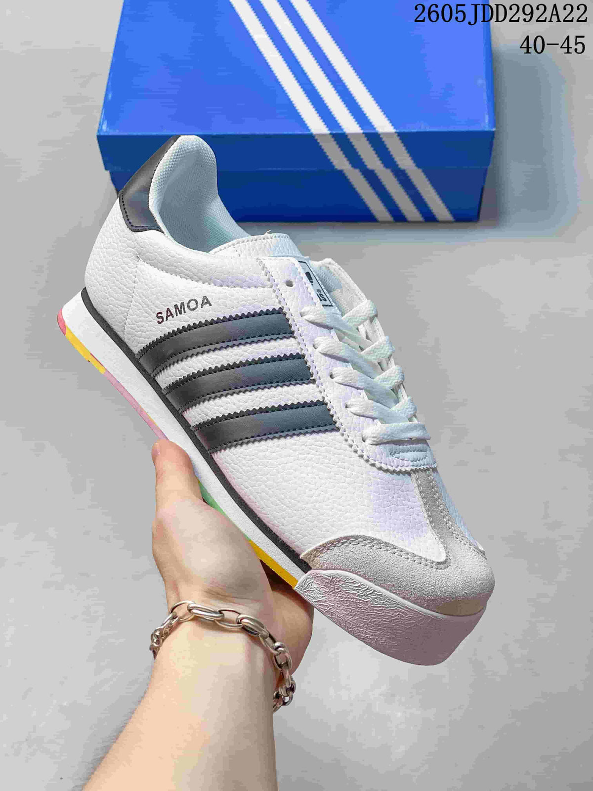 White Adidas Samoa low-top sneaker with dark stripes and gray toe overlay
