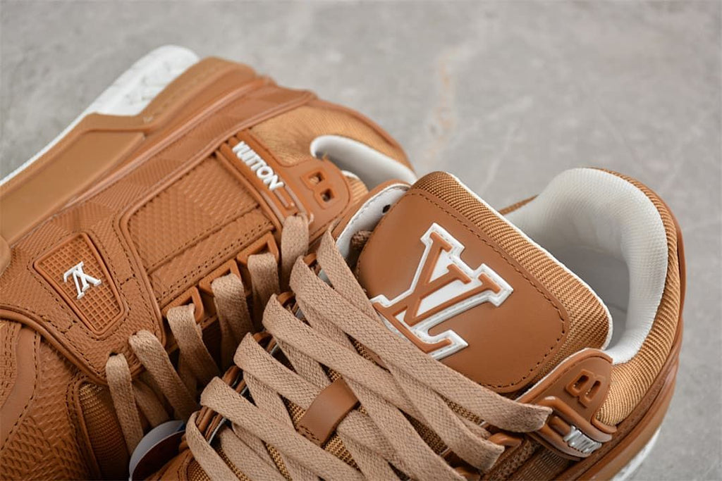 Close-up of the brown sneaker tongue, tan laces, and logo details.