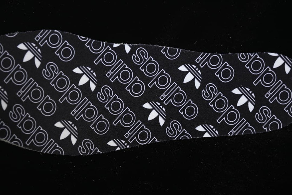 Black insole with adidas Trefoil and wordmark pattern