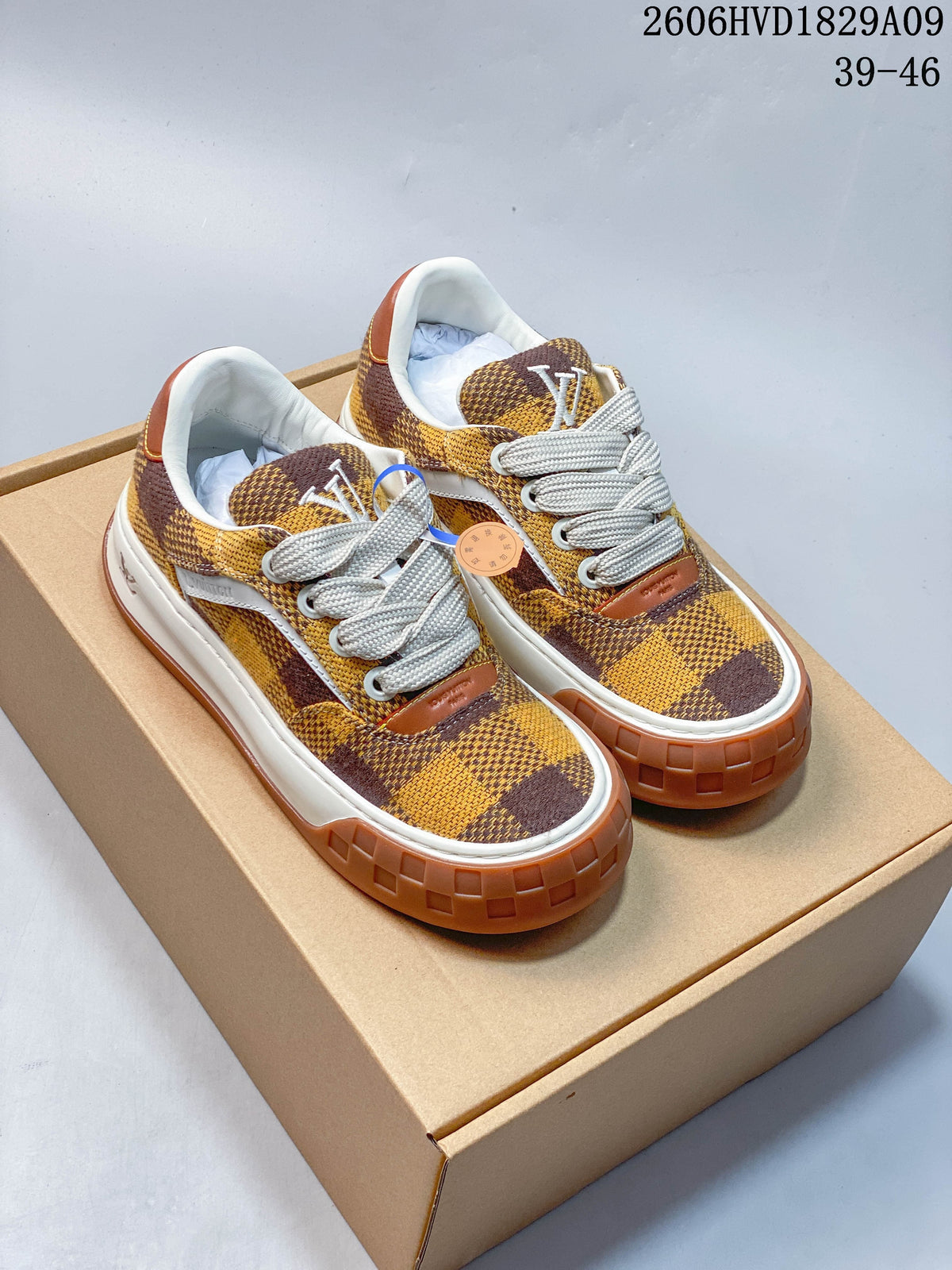 Pair of brown and yellow checkerboard low-top sneakers with white laces and contrasting brown outsoles