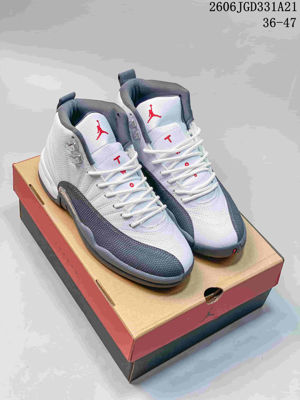 White and gray high-top Air Jordan 12 shoes displayed on a shoe box
