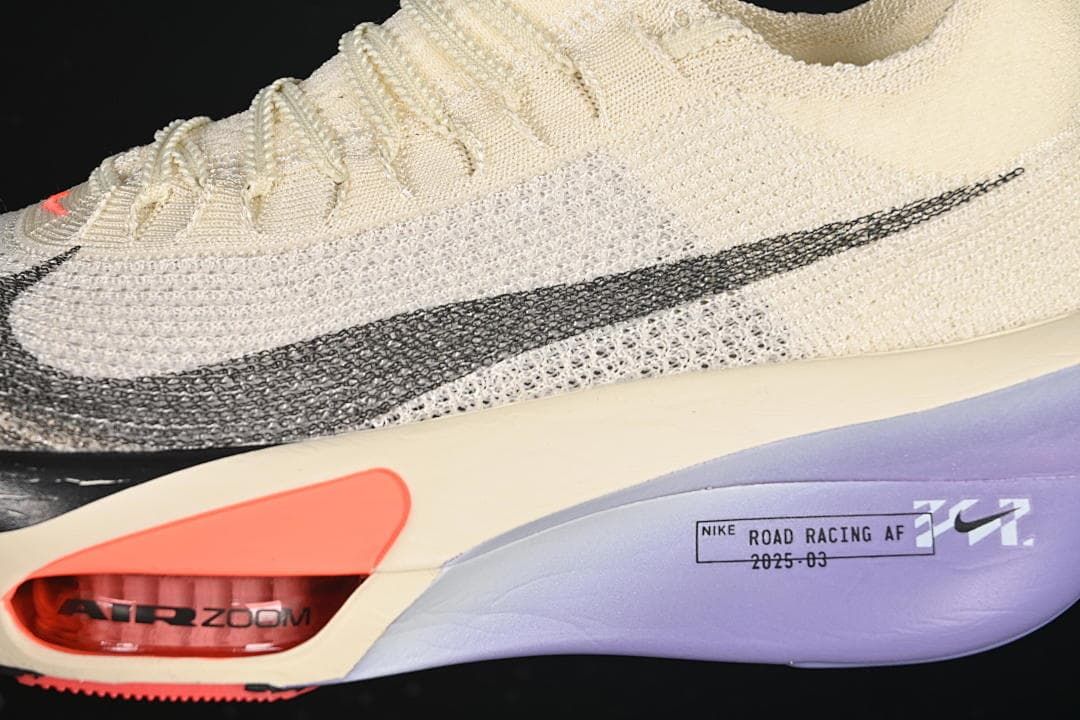 Close-up of the black side Swoosh and coral sole detail