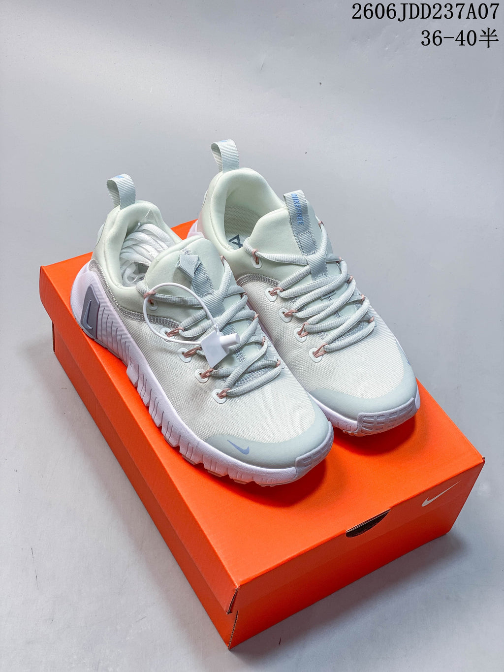 Pair of pale mint and white Nike Free Metcon 6 shoes on an orange shoebox