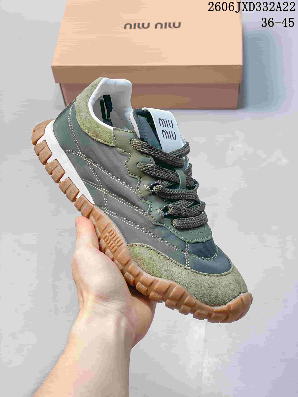 Angled view of a green and gray Miu Miu Tyre sneaker with contrasting stitching