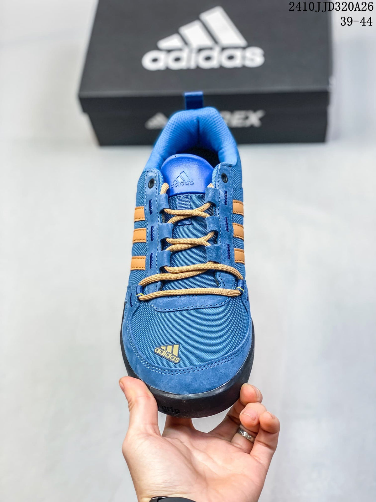 Front view of the blue adidas Daroga Plus shoe with tan laces and orange stripes.