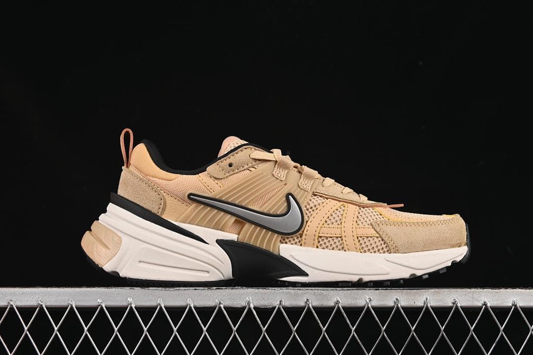 Side profile of one tan sneaker with a silver Swoosh