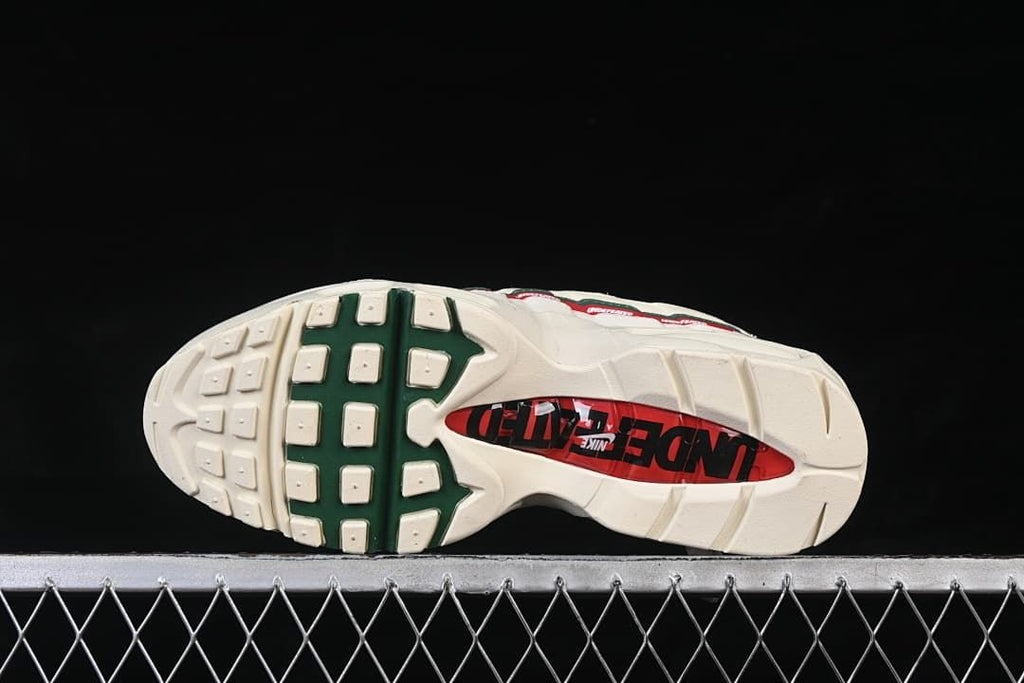Outsole view with off-white tread and dark green and red sections.