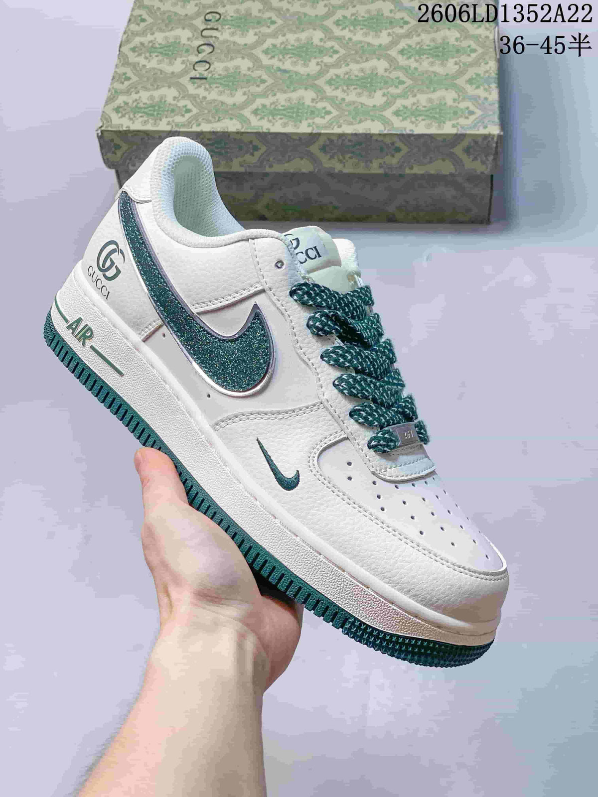 White low-top sneaker with teal accents, patterned laces and glitter-effect Swoosh.