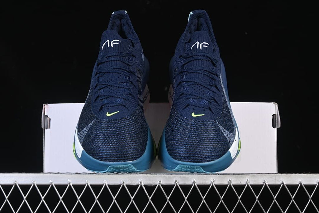 Front view of the pair of navy running shoes on a box.