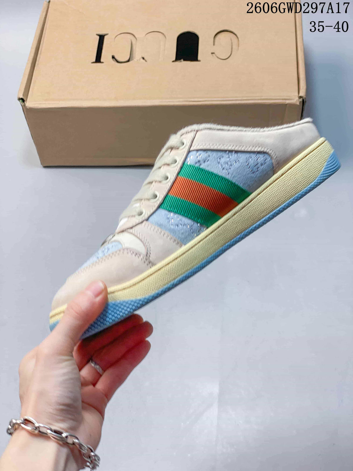 Side view of a lace-up sneaker with light blue panels and green and red stripes