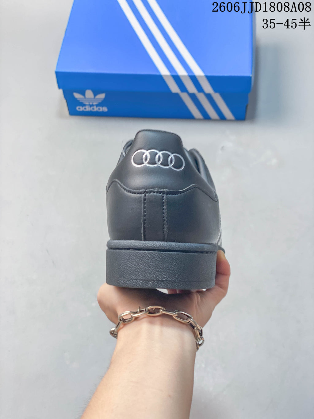 Rear view of a charcoal Adidas Superstar sneaker.