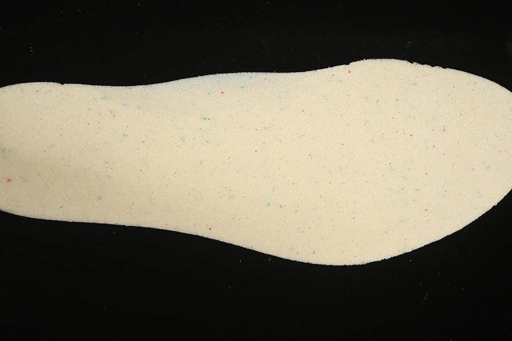 Cream-colored shoe insole shown against a black background