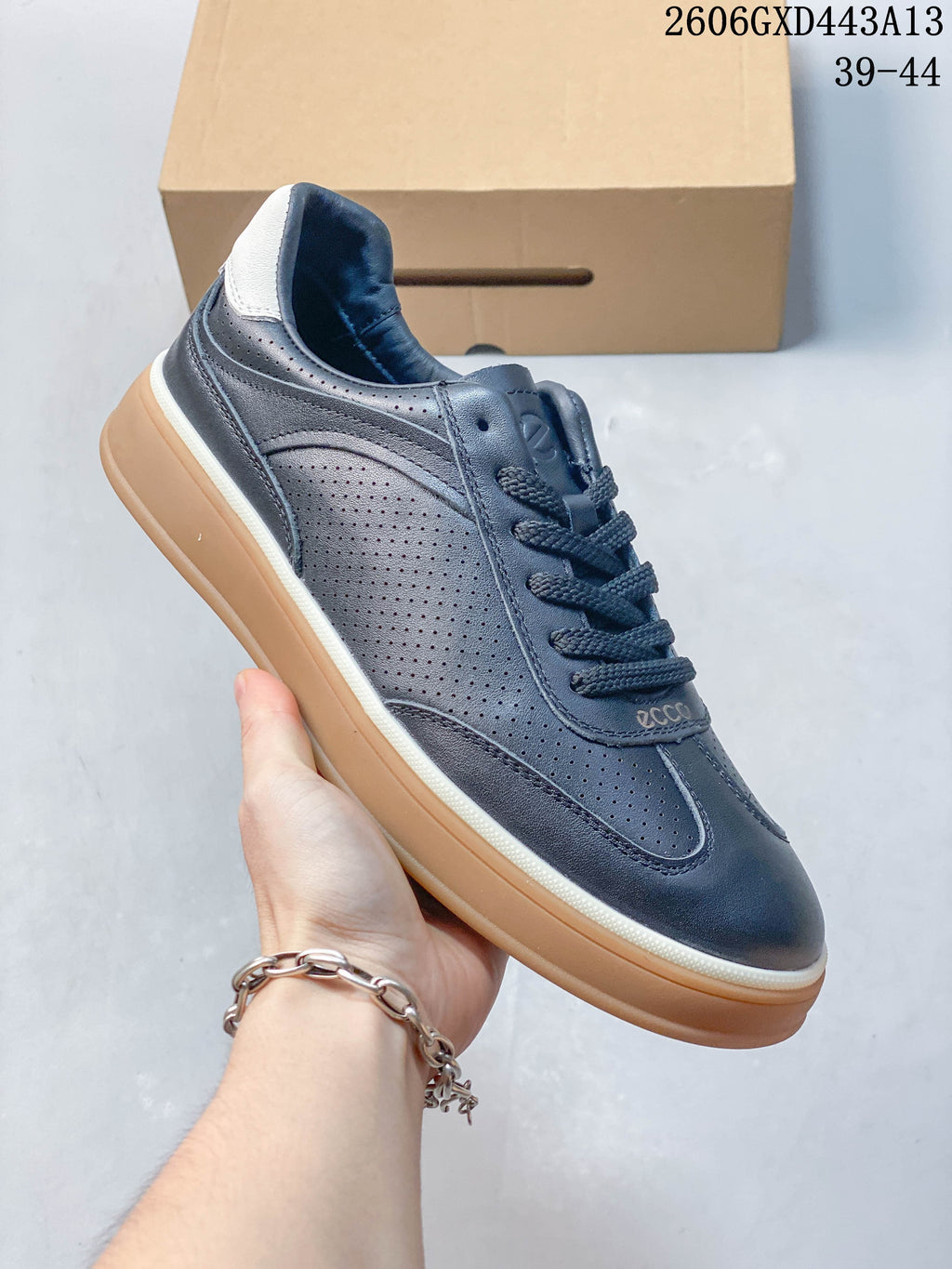 Angled view of a navy perforated sneaker with a white heel accent and gum-colored sole