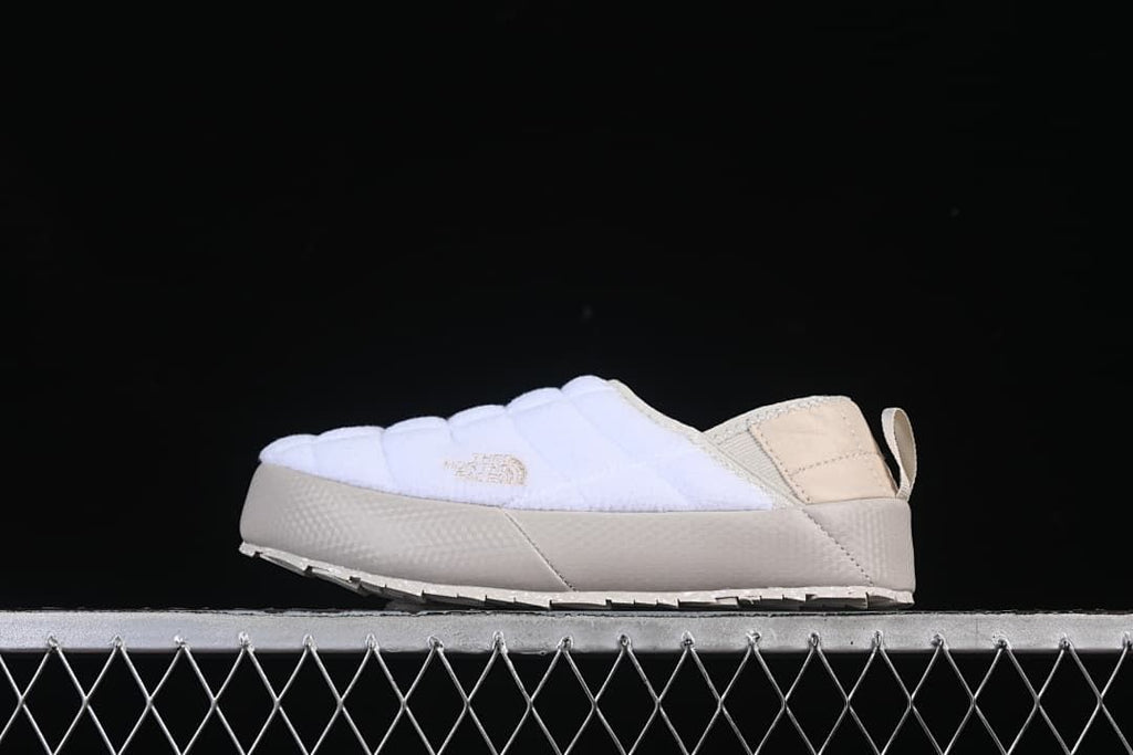 Side view of a white and beige The North Face mule