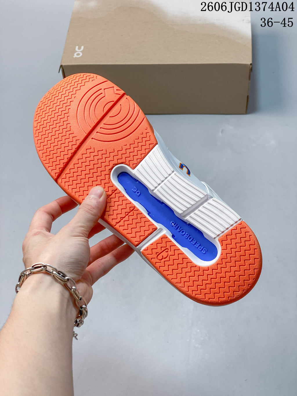 Underside view showing the orange tread and blue center detail of the sneaker outsole